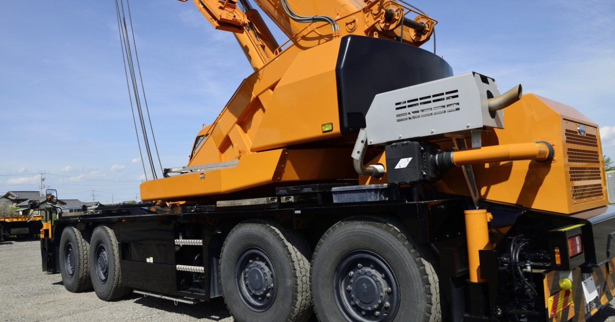 A mobile construction crane with large wheels to provide stability during lifts. The crane is extended upwards.